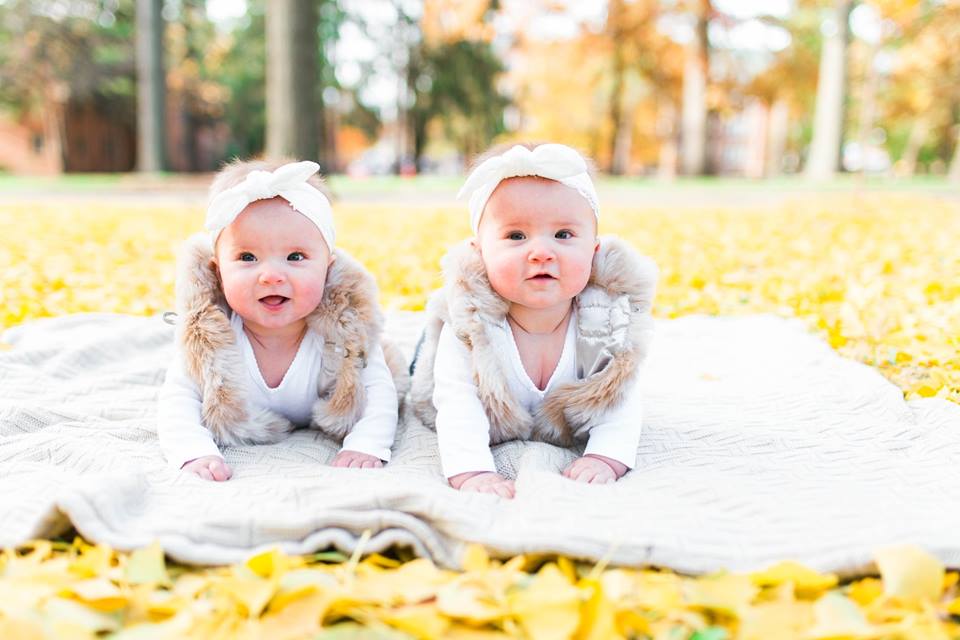 twin 6 month old baby girls on a blanket on yellow leaves